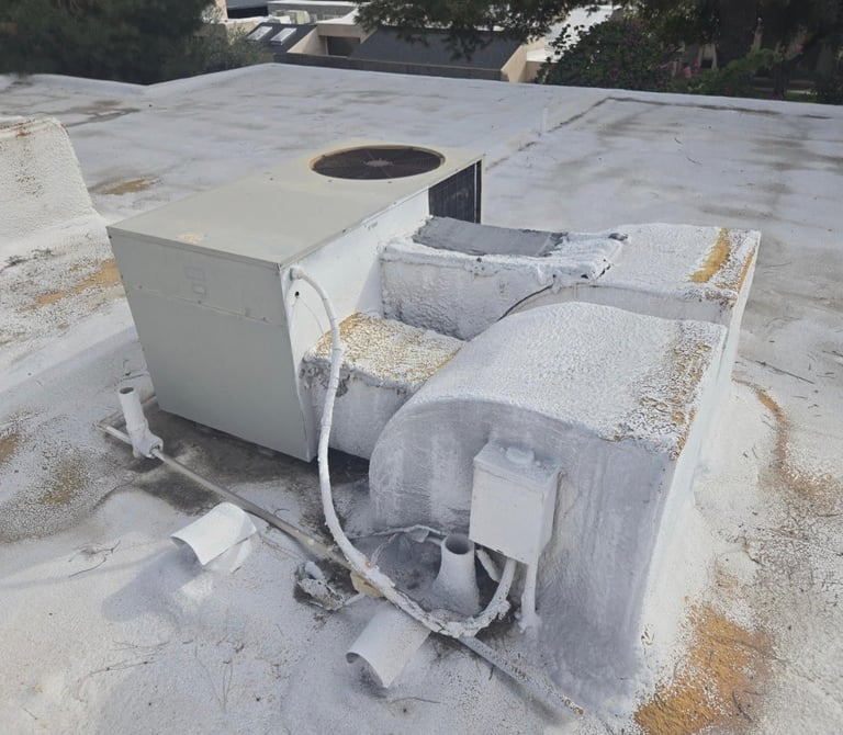 HVAC rooftop unit installation with white metal components and ductwork on concrete roof surface