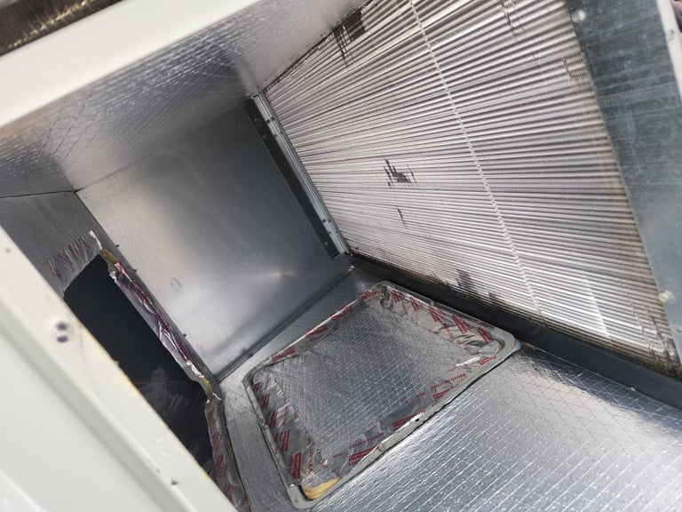 Close-up view of an open air filter compartment showing a dirty white and black pleated air filter